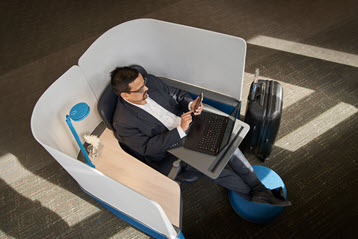 A person sitting in a chair with a laptop.