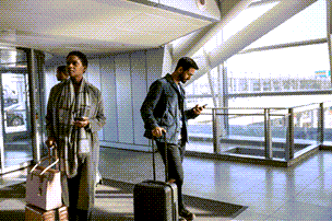 People at an airport checking their wireless devices.